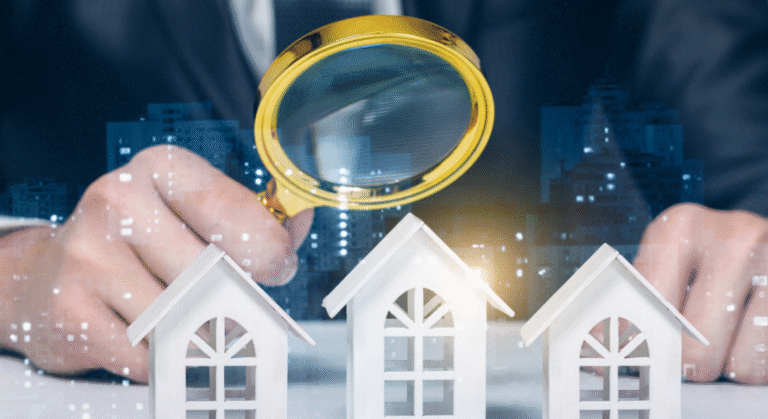 Person uses a yellow magnifying glass to examine three white miniature houses on a table, with a city backdrop in view, symbolizing property inspection.